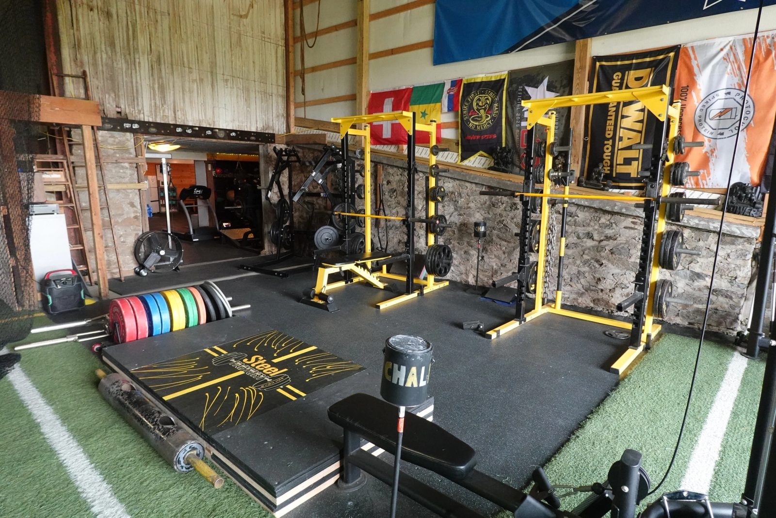 Steel Factory squat rig with international flags and stone barn walls
